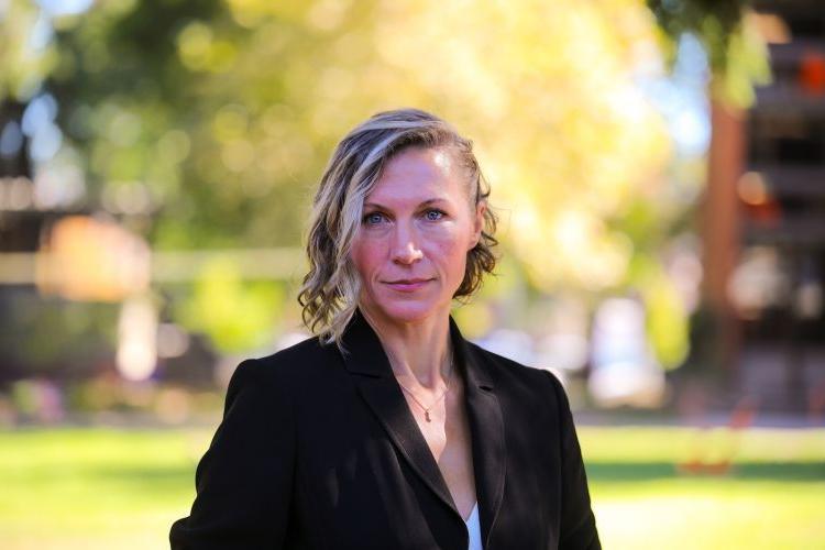 Woman in black blazer talks a headshot